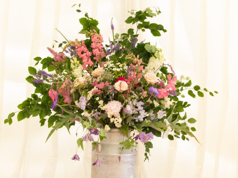 Milk Churn filled with colourful flowers for wedding reception.