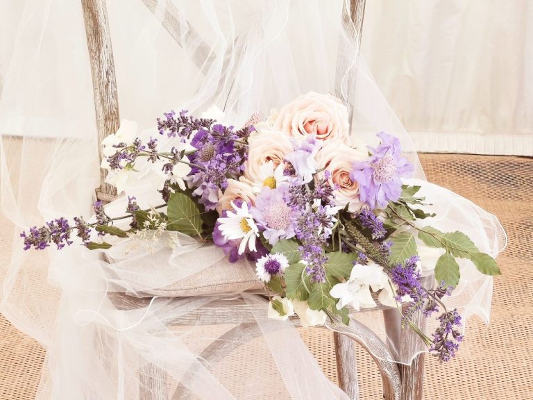 Pastel Bridal Bouquet laid on top of a veil on a chair